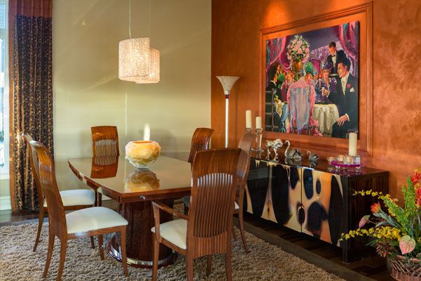 White rug under wooden table with big painting on the wall. 