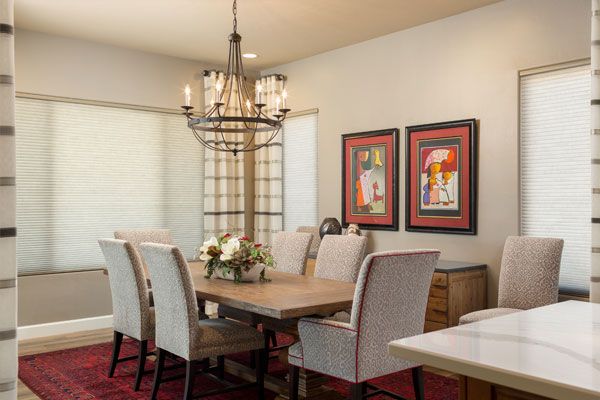 Red rug under table with light colored walls. 