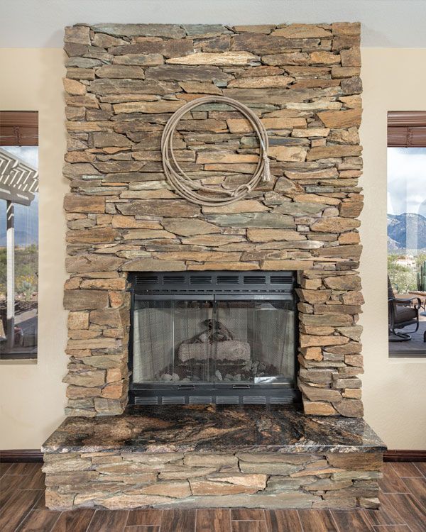 Large fireplace with dark wooden floors. 