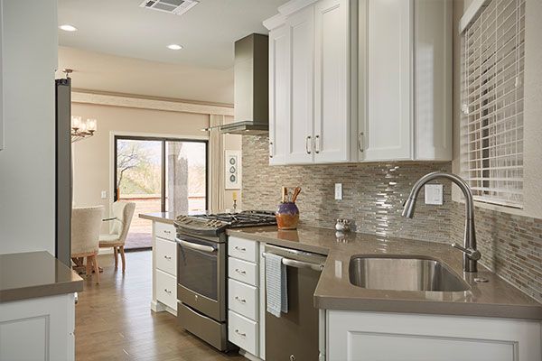 Dark wooden floors with tiled walls behind the sink. 