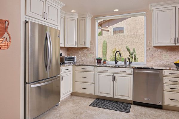 White cabinets with textured light colored walls. 