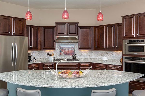 Dark wooden cabinets with small kitchen island. 