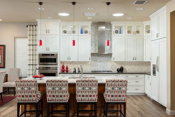 White kitchen cabinets with dark wooden floor. 