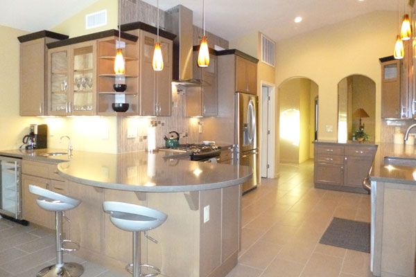 Kitchen with bar seats and yellow walls. 