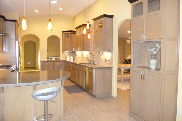 Yellow walls with low hanging lights and wooden cabinets. 