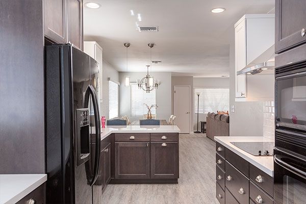 Dark wooden cabinets with light colored kitchen walls. 