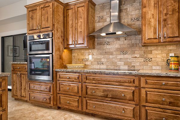 tile walls behind kitchen oven with wooden cabinets. 