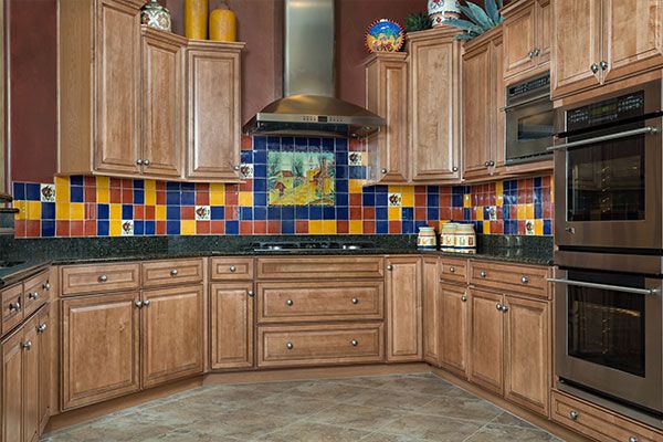 Multi colored tile with light color wooden cabinets. 