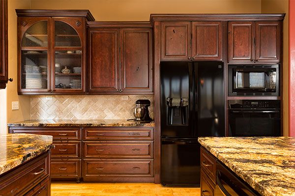 dark wooded cabinets with marble kitchen counter tops. 