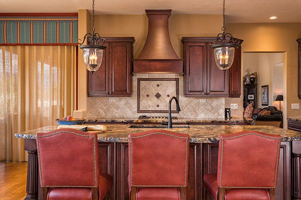 Kitchen with red seats and marble counter tops. 