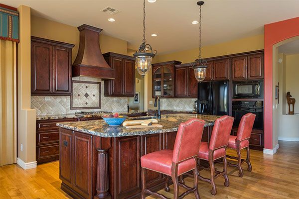 light colored wooden floor with dark red cabinets. 