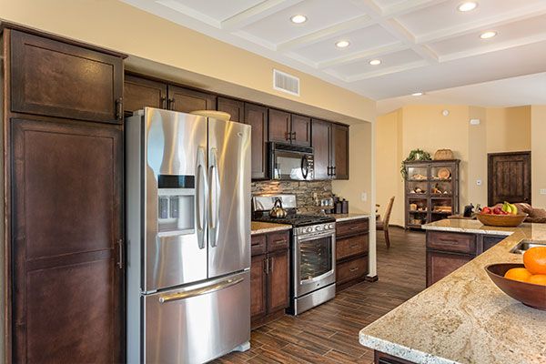 Dark wooden cabinets with light colored walls in a modern kitchen design. 