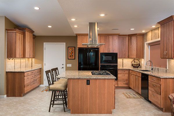 Wooden cabinets with marbled kitchen counter tops. 
