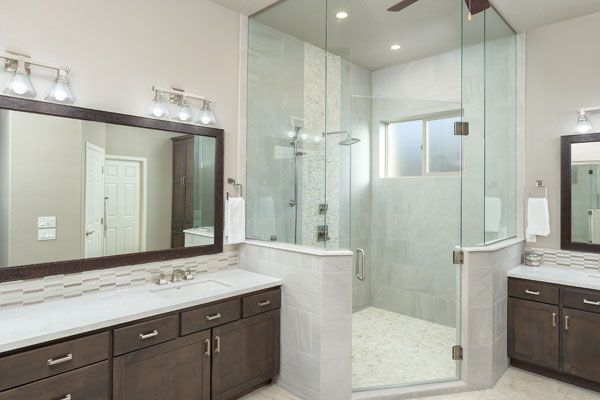 Glass shower with light colored walls. 