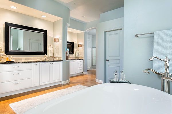 Light colored wooden floor with blue bathroom walls. 