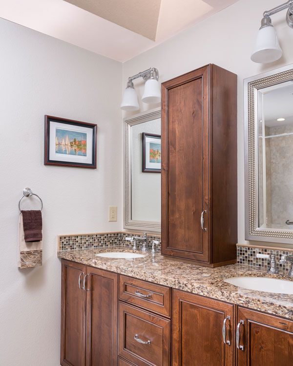Light colored walls with wooden bathroom cabinets. 