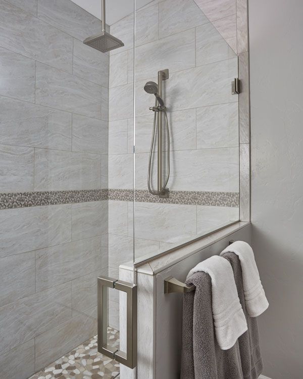 Light colored walls with glass shower door. 