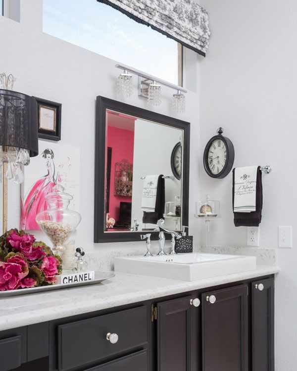 Dark colored kitchen cabinets under sink with white and pink walls. 