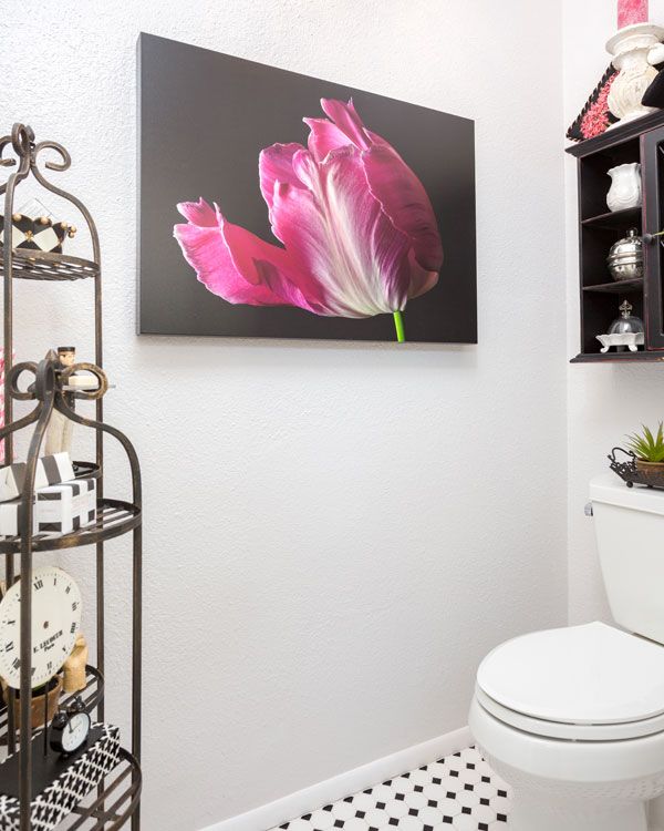Light colored walls and black and white floor around bathroom toilet. 