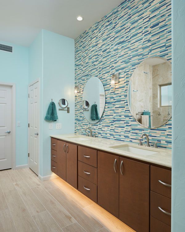 Light blue colored walls in modern double sink bathroom design. 