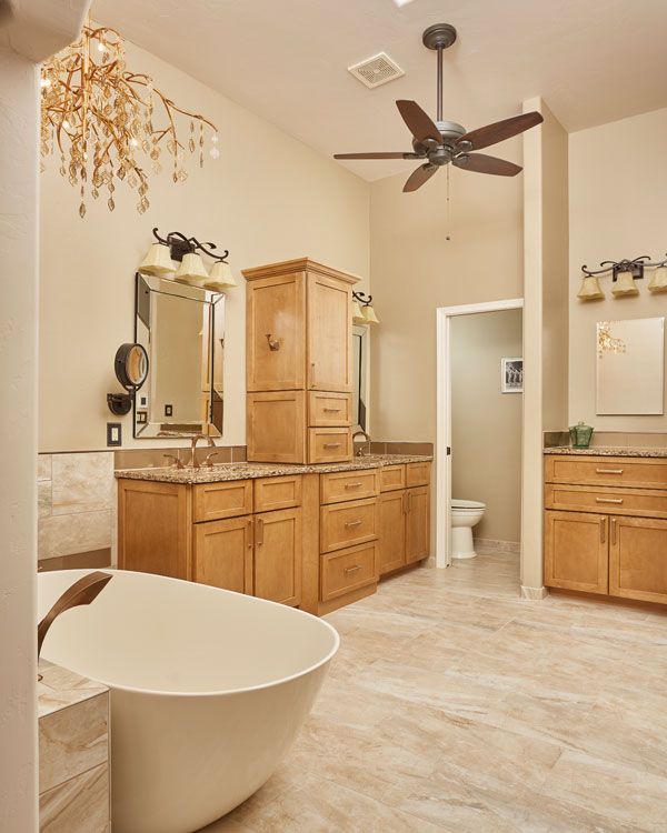 Light colored walls with modern bathtub and 2 bathroom sinks. 