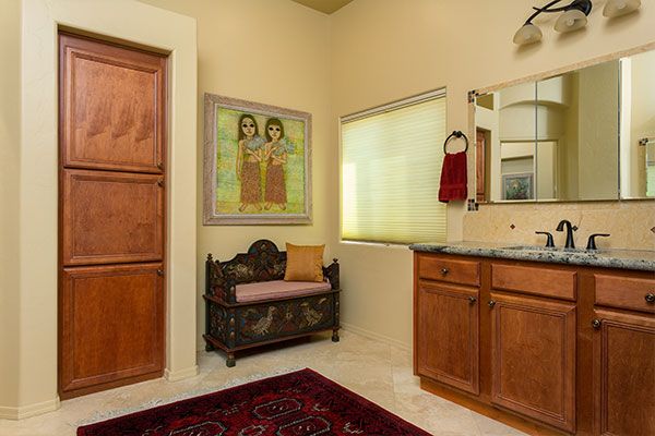 Light colored walls in bathroom with marbled counter top around sink. 