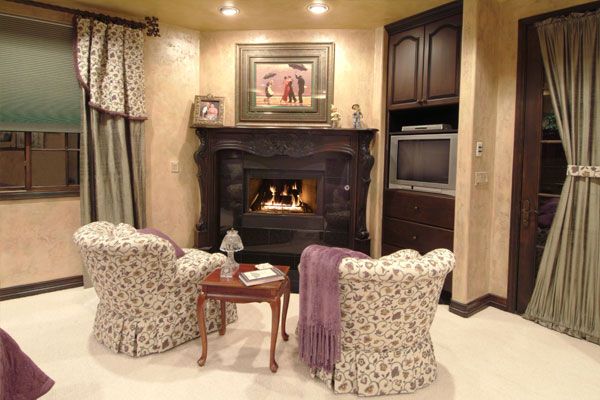 Fireplace with 2 seats and a small lamp desk. 