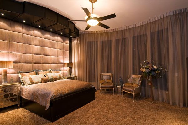 lights on ceiling over the bed with textured wall.