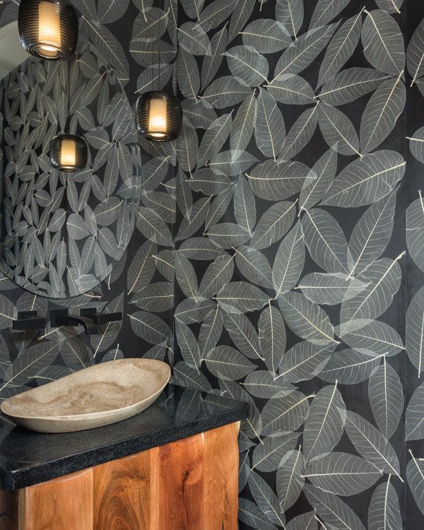 Powder room with leaf designed walls around a modern sink. 