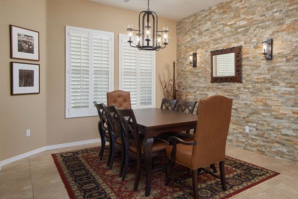 Dining room with tile floor and light brown walls. 