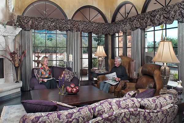 dark brown table with dark curtains on large windows. 
