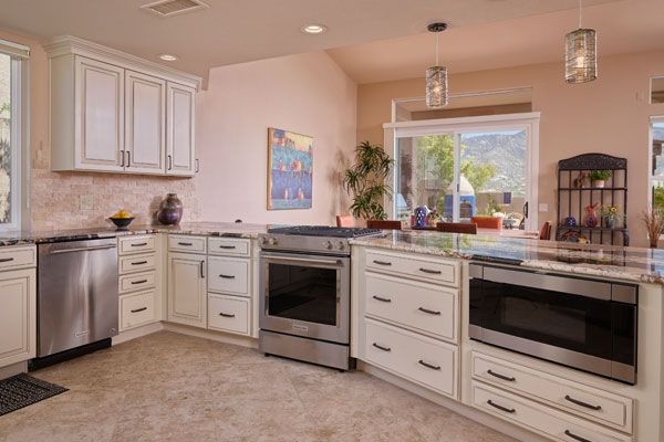 Light pink colored walls with white cabinets in open design kitchen. 