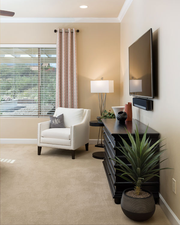 Bedroom with carpet and black drawers.