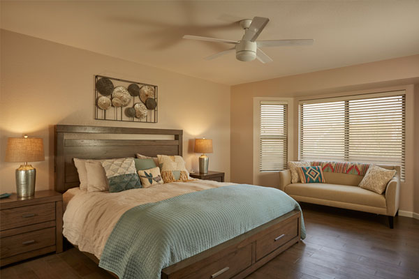 Wood floors with with a couch in a bedroom.
