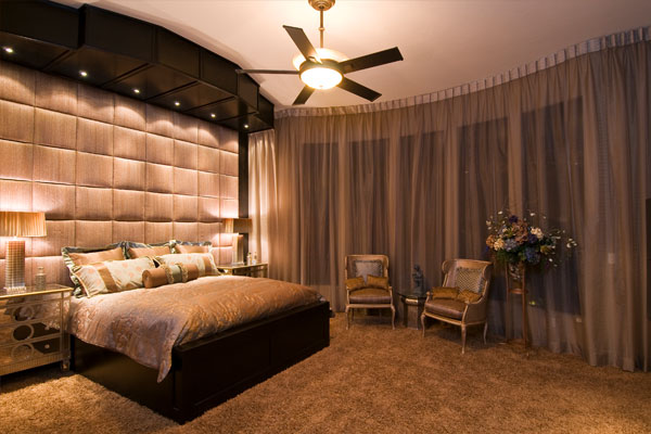 lights on ceiling over the bed with textured wall.